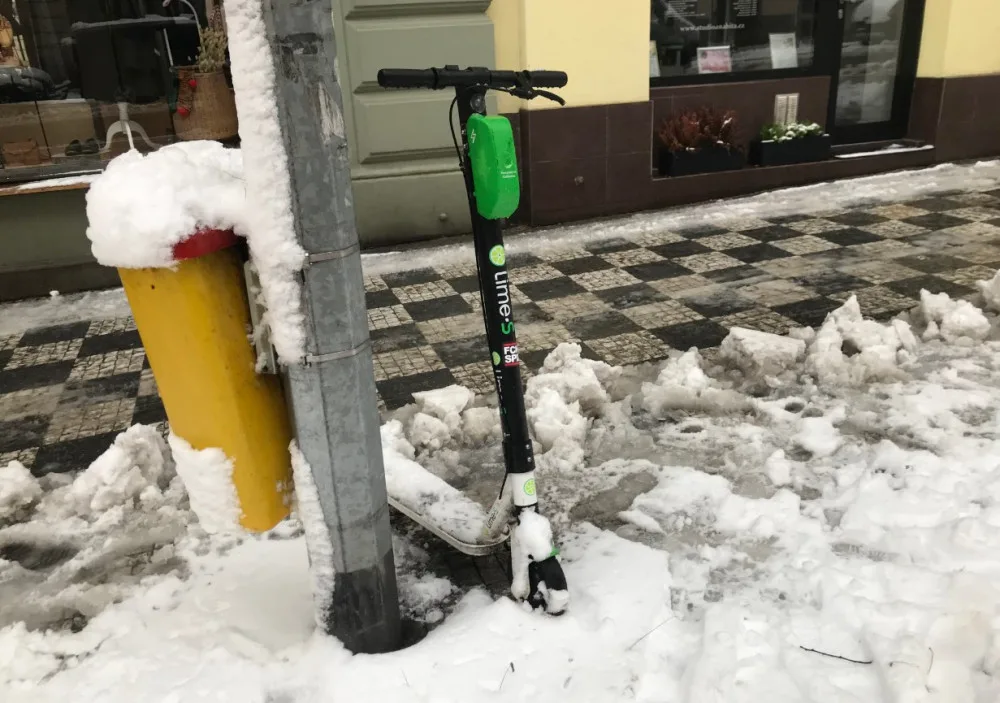 Koloběžka Lime v zasněžené Praze.