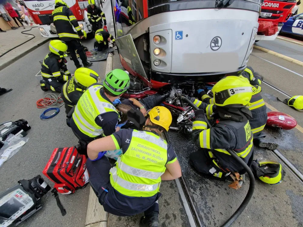 Motorkář skončil zaklíněný pod tramvají. Při vědomí ho vyprošťovali hasiči
