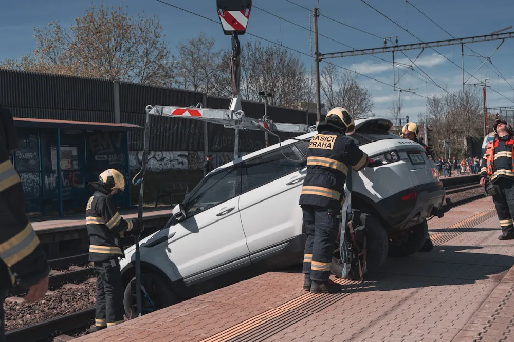 VIDEO: Řidička zaparkovala, auto ale nezabrzdila. Vůz sjel na koleje a blokoval vlaky