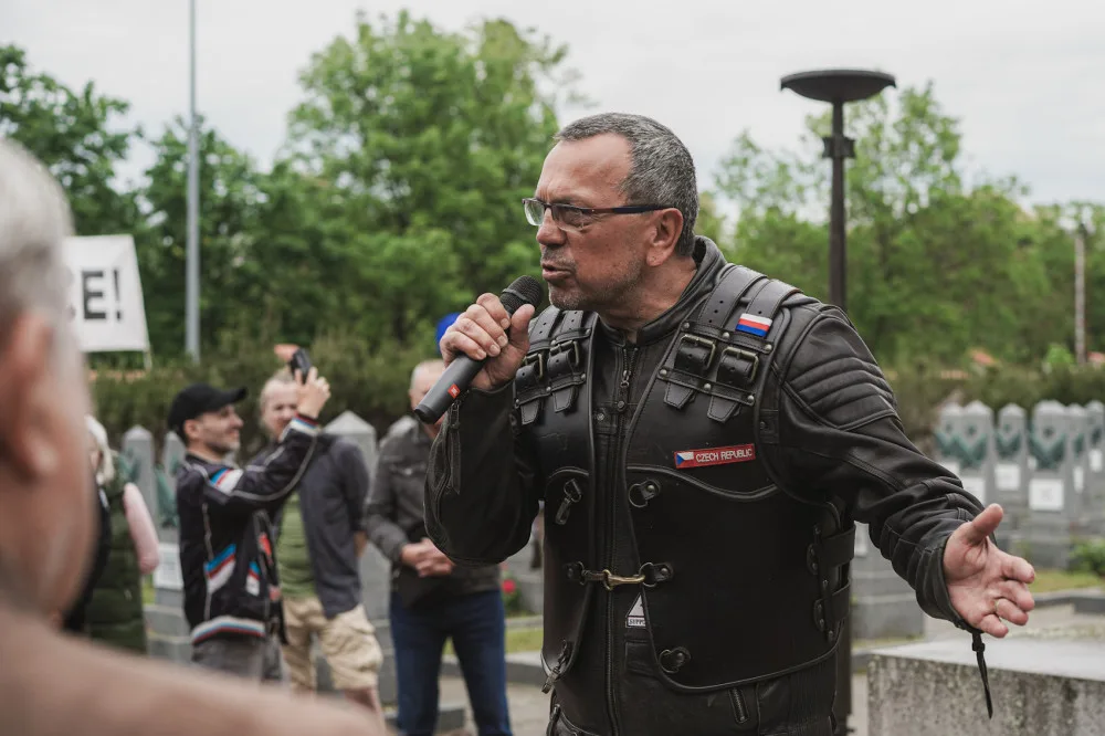 FOTOGALERIE: Vztyčené prostředníčky, karafiáty a ruské vlajky. Podívejte se, jak vypadala návštěva Nočních vlků na Olšanských hřbitovech