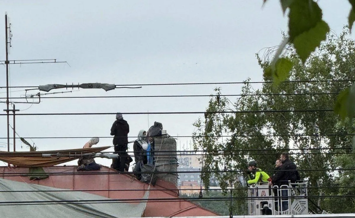 Squatteři už jsou na střeše domu v Dejvicích třetí den, vyjednává s nimi policie