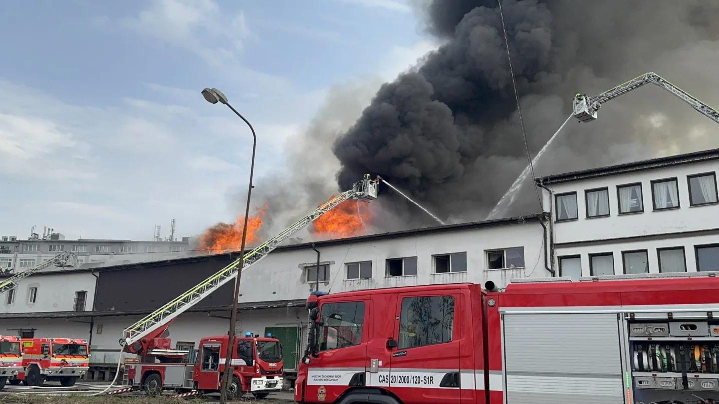 Na Žižkově hoří ubytovna, hasiči zachraňují lidi pomocí žebříků