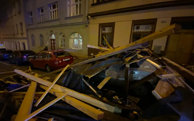 FOTO, VIDEO: Trámy z rozestavěné střechy na Žižkově zasypaly několik zaparkovaných aut