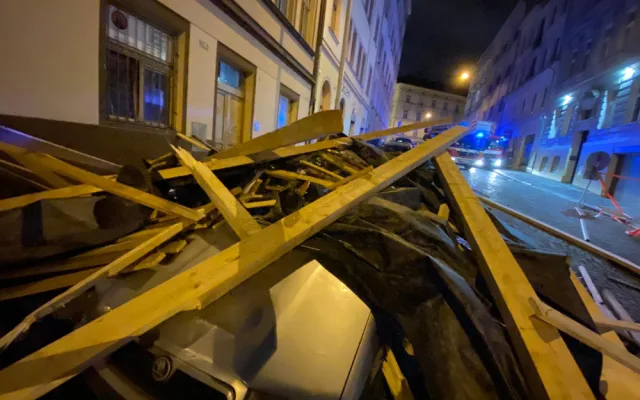 FOTO, VIDEO: Trámy z rozestavěné střechy na Žižkově zasypaly několik zaparkovaných aut