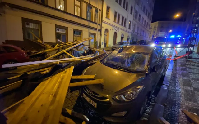 FOTO, VIDEO: Trámy z rozestavěné střechy na Žižkově zasypaly několik zaparkovaných aut