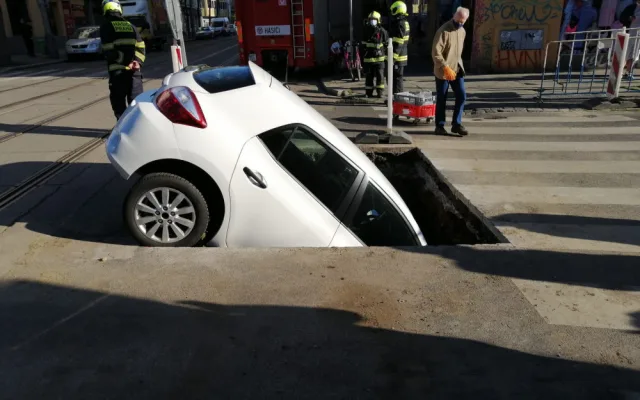 FOTO: Řidička v Praze 10 vjela do výkopu na silnici. Vyprostit ji museli hasiči