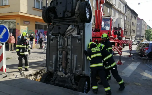 FOTO: Řidička v Praze 10 vjela do výkopu na silnici. Vyprostit ji museli hasiči