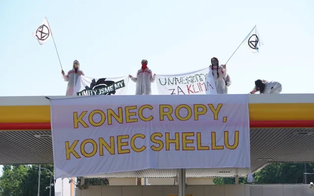 Aktivisté obsadili střechy tří pražských čerpacích stanic. Hasiči jim pomáhali dolů