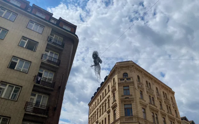 Nad ulicí v centru Prahy se vznáší nová socha. Lidé jsou nadšení i zděšení