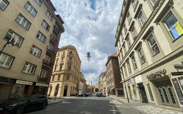 Nad ulicí v centru Prahy se vznáší nová socha. Lidé jsou nadšení i zděšení