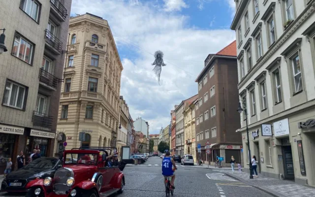Nad ulicí v centru Prahy se vznáší nová socha. Lidé jsou nadšení i zděšení