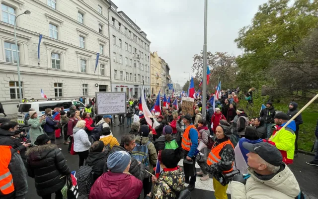 Lidé nesou transparenty a vlajky