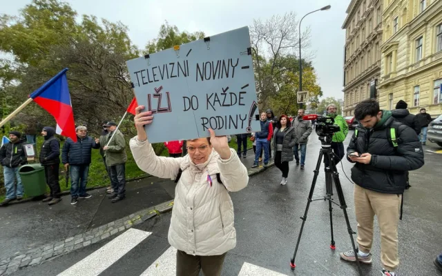 Lidé nesou transparenty a vlajky