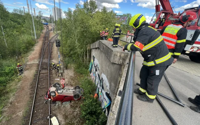 Sedmdesátiletá řidička spadla s autem z deseti metrů na koleje