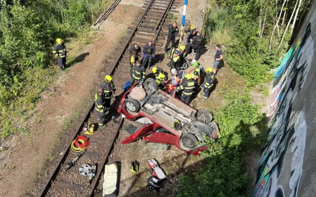 Sedmdesátiletá řidička spadla s autem z deseti metrů na koleje