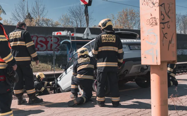 VIDEO: Řidička zaparkovala, auto ale nezabrzdila. Vůz sjel na koleje a blokoval vlaky
