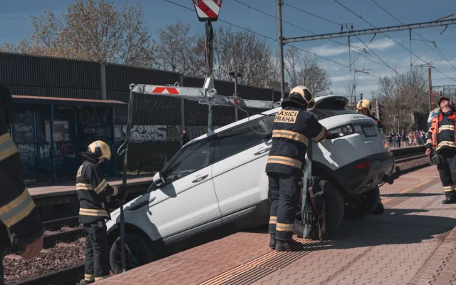VIDEO: Řidička zaparkovala, auto ale nezabrzdila. Vůz sjel na koleje a blokoval vlaky