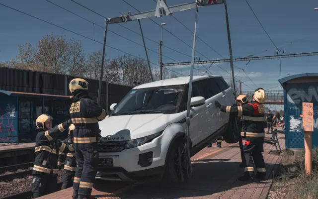 VIDEO: Řidička zaparkovala, auto ale nezabrzdila. Vůz sjel na koleje a blokoval vlaky