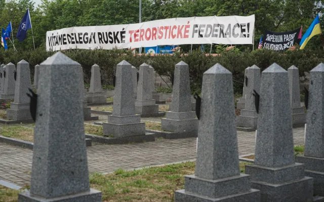 FOTOGALERIE: Vztyčené prostředníčky, karafiáty a ruské vlajky. Podívejte se, jak vypadala návštěva Nočních vlků na Olšanských hřbitovech