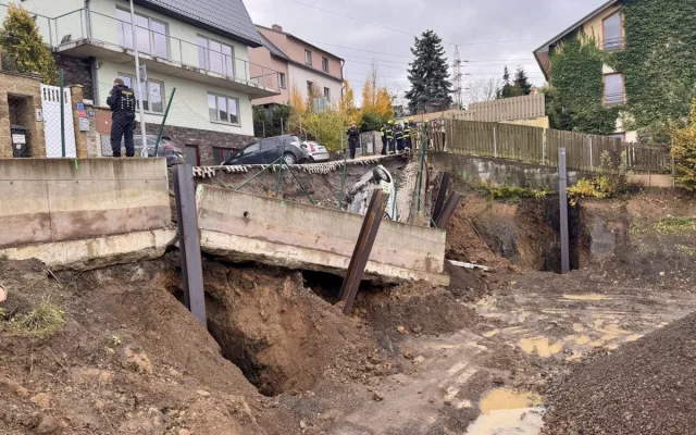Na stavbě v Praze se utrhl svah, auto městské policie skončilo na střeše