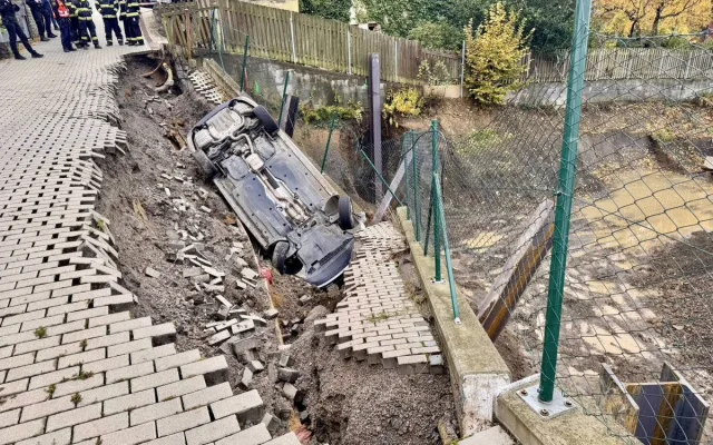 Na stavbě v Praze se utrhl svah, auto městské policie skončilo na střeše