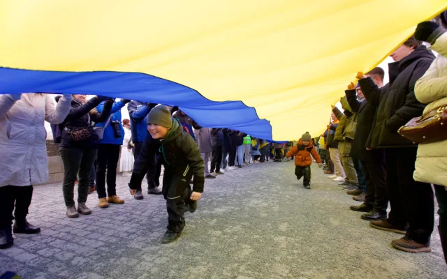 Lidé na Karlově mostě oslavili Den jednoty Ukrajiny, nesli několikametrovou vlajku