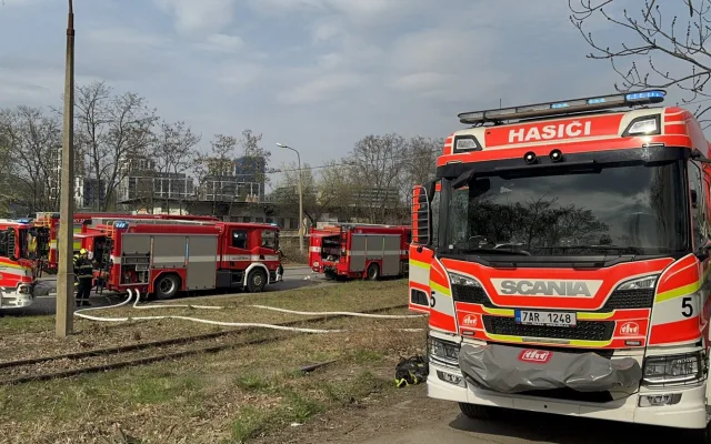 Na Žižkově hoří ubytovna, hasiči zachraňují lidi pomocí žebříků