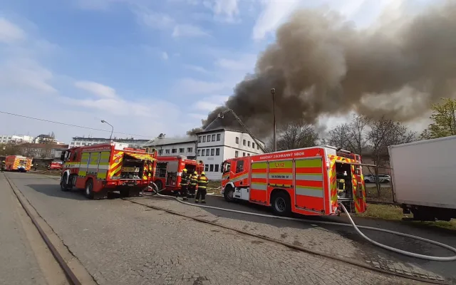Na Žižkově hoří ubytovna, hasiči zachraňují lidi pomocí žebříků