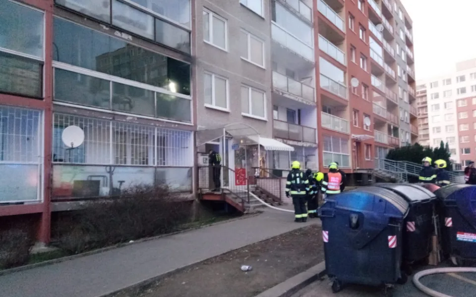 Při požáru bytu na Černém Mostě hasiči evakuovali přes třicet osob. Jeden člověk se zranil