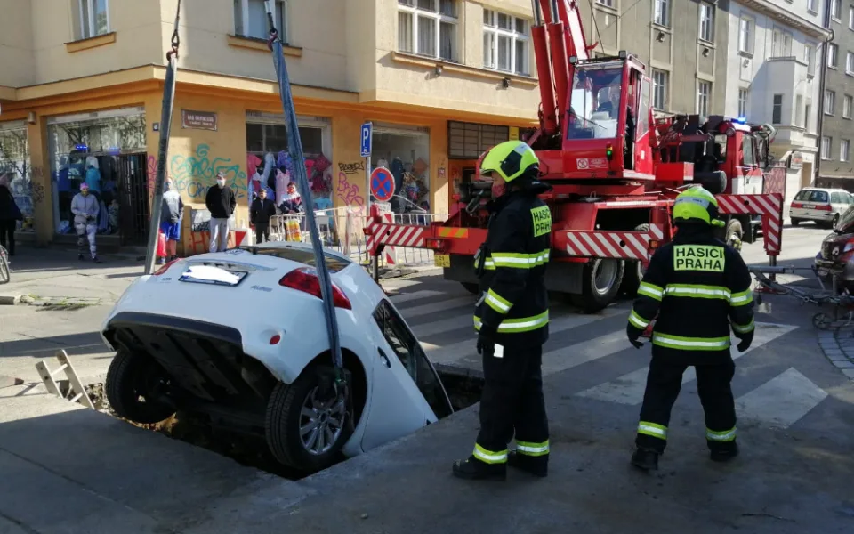 FOTO: Řidička v Praze 10 vjela do výkopu na silnici. Vyprostit ji museli hasiči