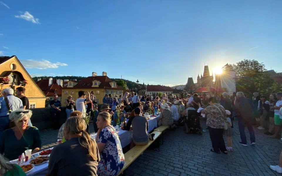 VIDEO: Lidé večeři u půlkilometrového stolu na Karlově mostě. Přivítali prázdniny