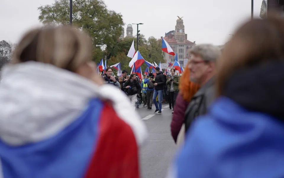 Lidé nesou transparenty a vlajky
