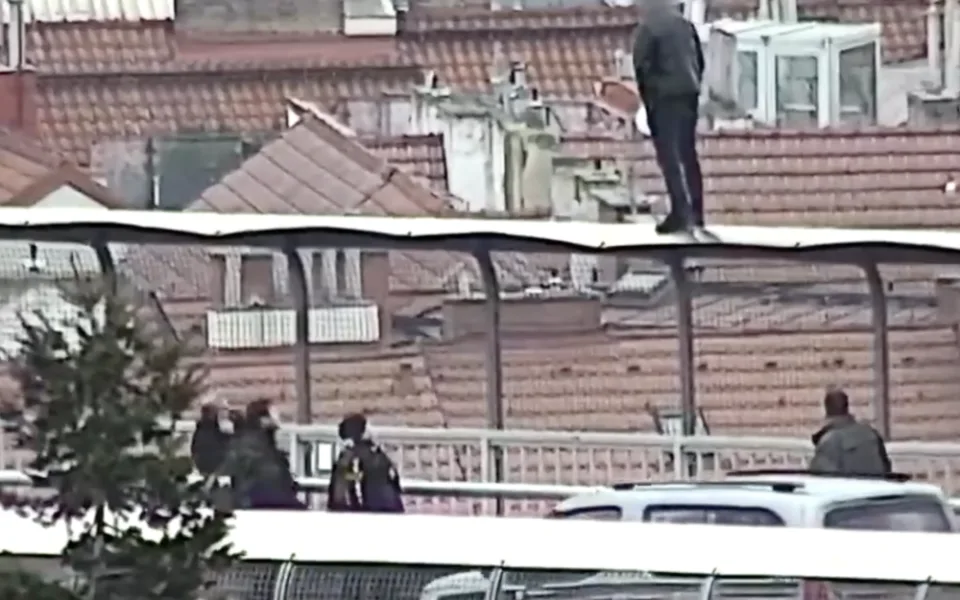 Muž stál na plotě a chtěl skočit.