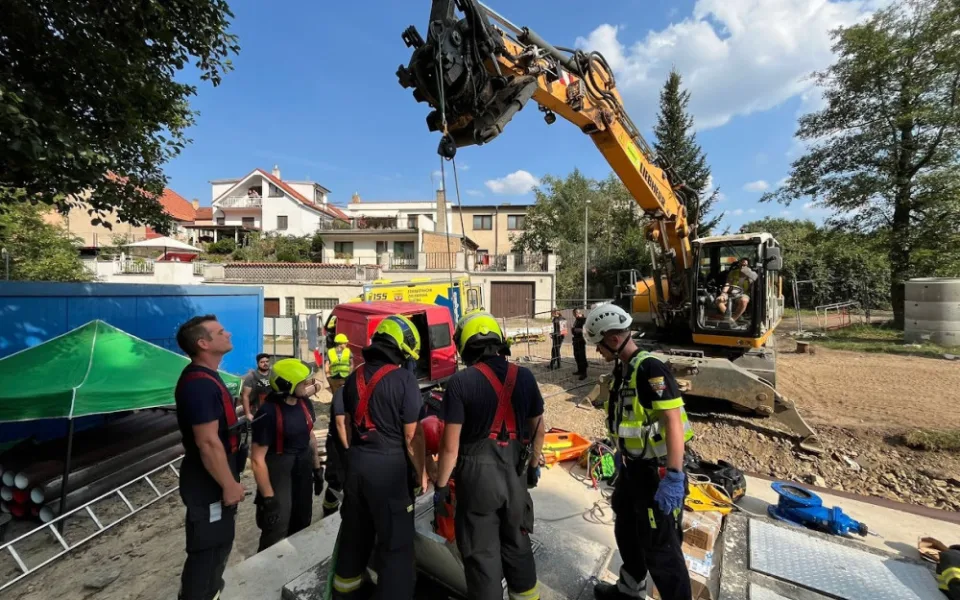 Hasiči vyprostili muže, který spadl do jímky. Využili k tomu bagr ze stavby