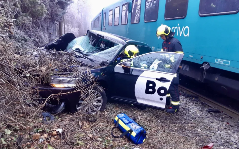 Vlak na přejezdu v Praze smetl auto, řidiče museli hasiči vystříhat