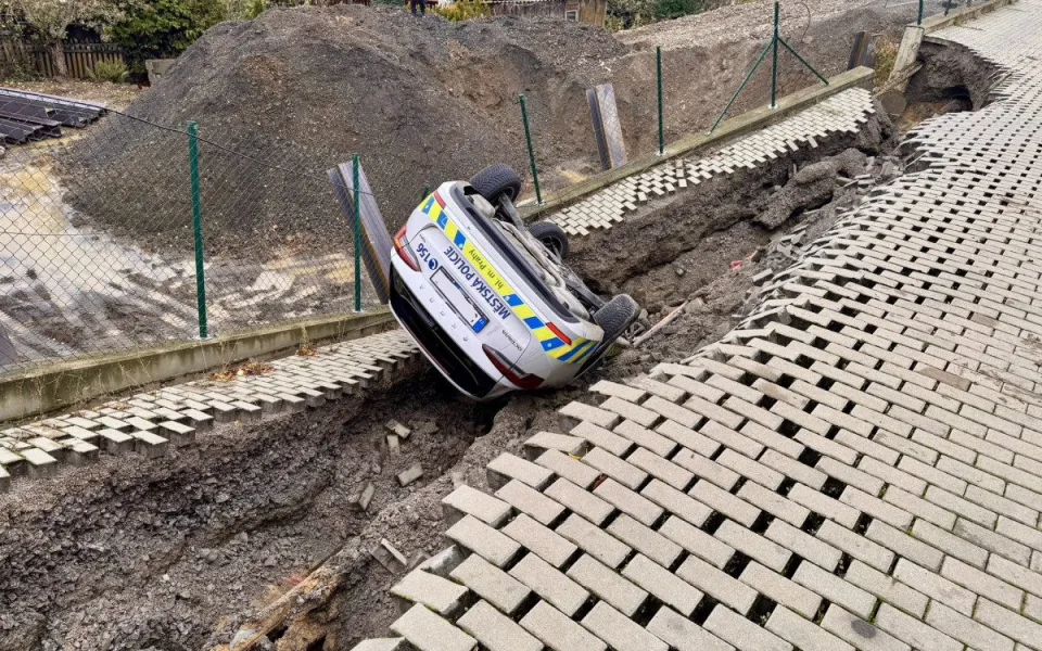 Na stavbě v Praze se utrhl svah, auto městské policie skončilo na střeše