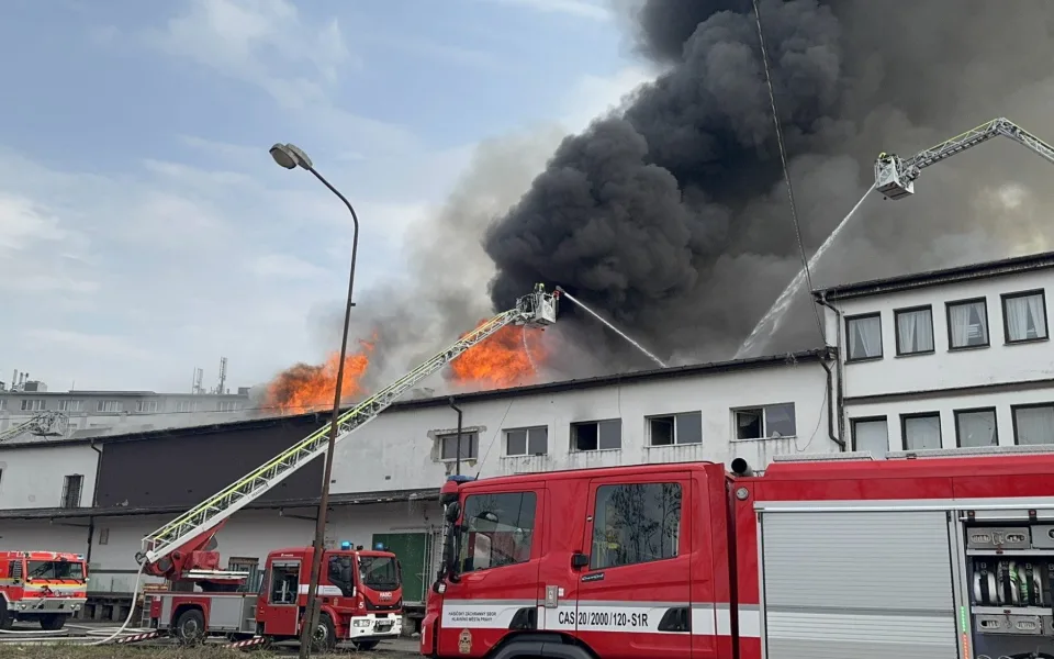 Na Žižkově hoří ubytovna, hasiči zachraňují lidi pomocí žebříků
